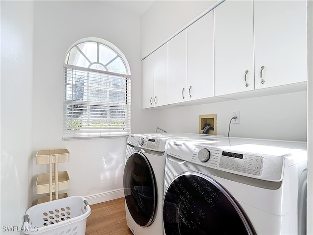 laundry room featuring cabinets, separate washer and dryer, plenty of natural light, and light wood-type flooring