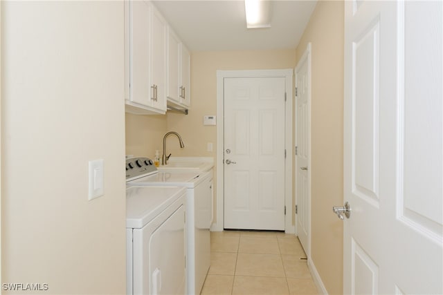 clothes washing area featuring cabinets, separate washer and dryer, light tile patterned floors, and sink