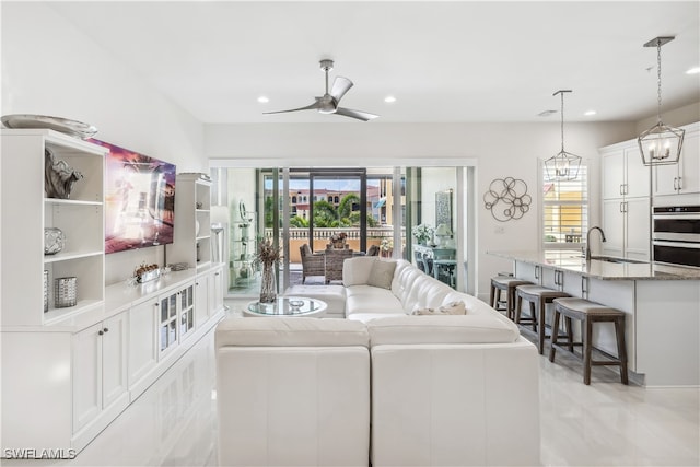 living room featuring ceiling fan and sink