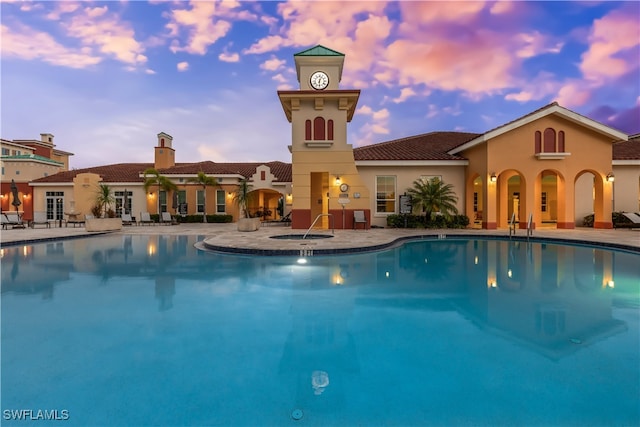 pool at dusk featuring a patio