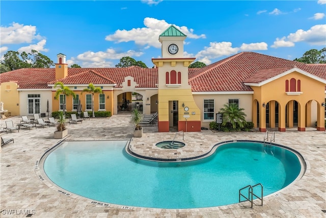 view of pool with a patio area and a hot tub