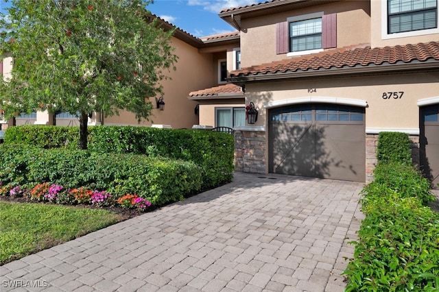 8757 Bellano Ct Unit 6-104, Naples, FL 34119 - mediterranean / spanish home featuring a tiled roof, driveway, a garage, stone siding, and stucco siding