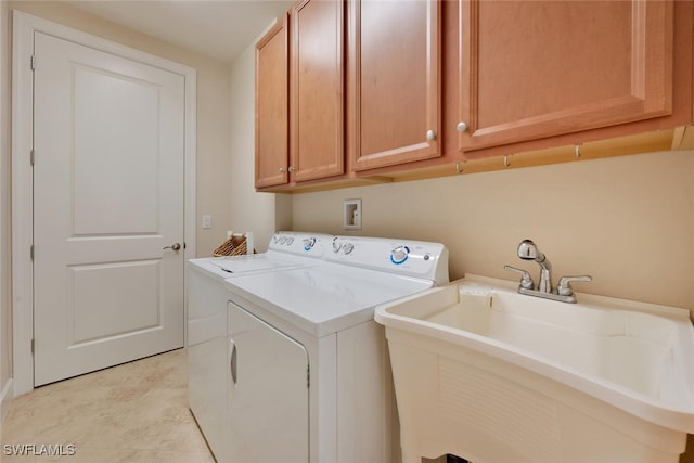 washroom featuring light tile patterned floors, sink, separate washer and dryer, and cabinets