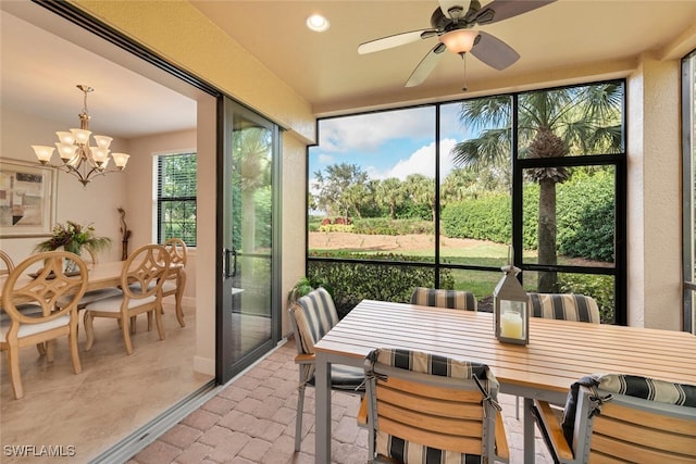 sunroom / solarium featuring ceiling fan with notable chandelier and plenty of natural light