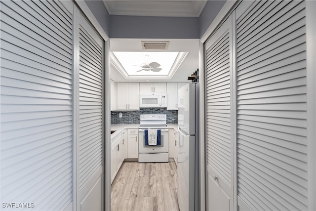 kitchen featuring white appliances, white cabinetry, light hardwood / wood-style floors, crown molding, and decorative backsplash