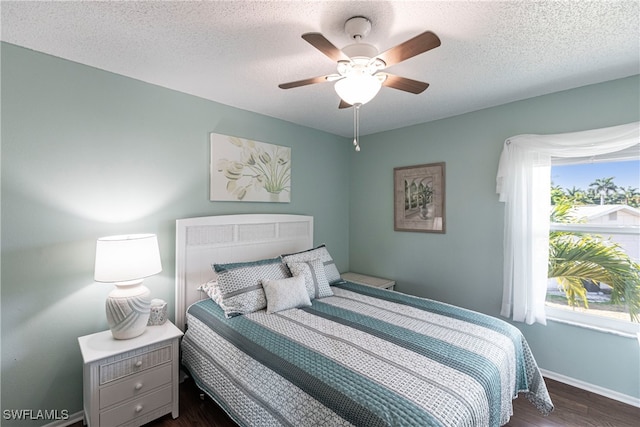 bedroom featuring a textured ceiling, dark hardwood / wood-style floors, and ceiling fan