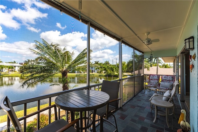 sunroom / solarium with a water view and ceiling fan