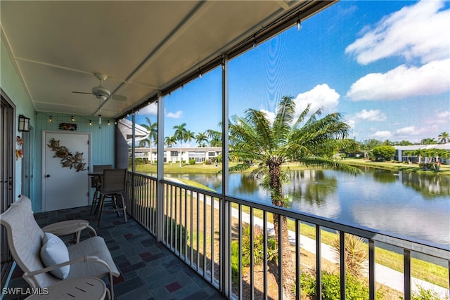 sunroom featuring a water view and ceiling fan