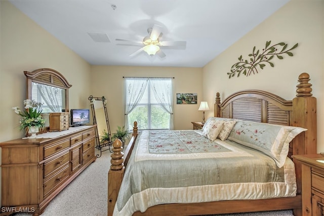 bedroom with ceiling fan, multiple windows, and light colored carpet