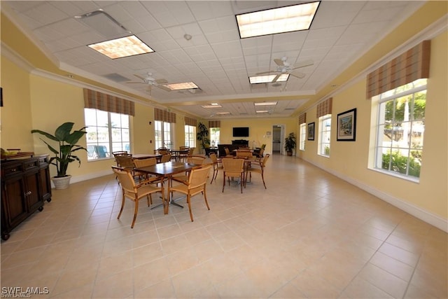 tiled dining area featuring ceiling fan, a tray ceiling, and plenty of natural light