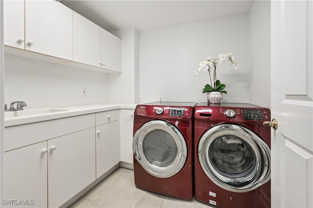 laundry area featuring cabinet space, washer and dryer, and a sink