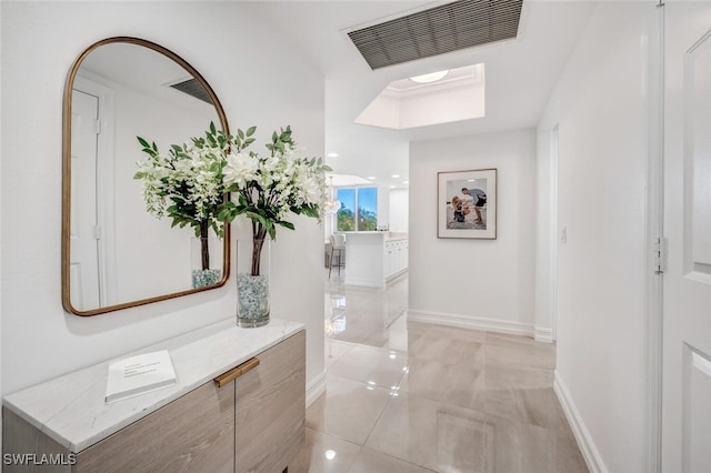 hall featuring light tile patterned flooring, baseboards, and visible vents