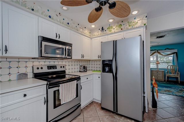 kitchen featuring backsplash, ceiling fan, appliances with stainless steel finishes, light tile patterned flooring, and white cabinetry