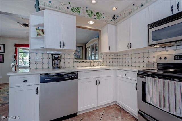 kitchen featuring backsplash, white cabinetry, sink, and appliances with stainless steel finishes