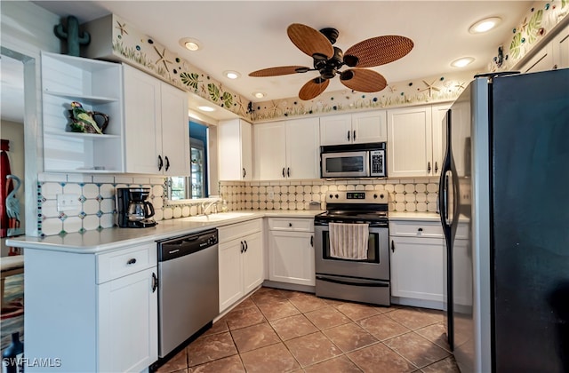 kitchen featuring sink, tile patterned floors, backsplash, white cabinets, and appliances with stainless steel finishes