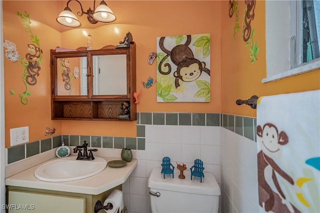 bathroom with vanity, toilet, and tile walls