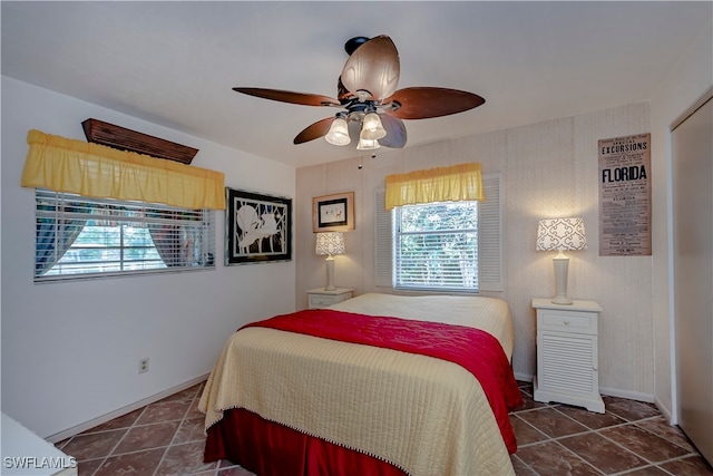 tiled bedroom featuring ceiling fan and multiple windows