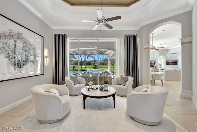 tiled living room featuring ceiling fan, crown molding, and a tray ceiling