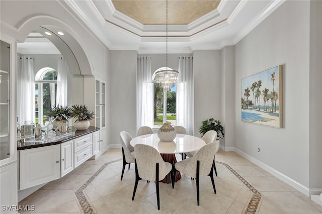 tiled dining area with a chandelier, a tray ceiling, and crown molding