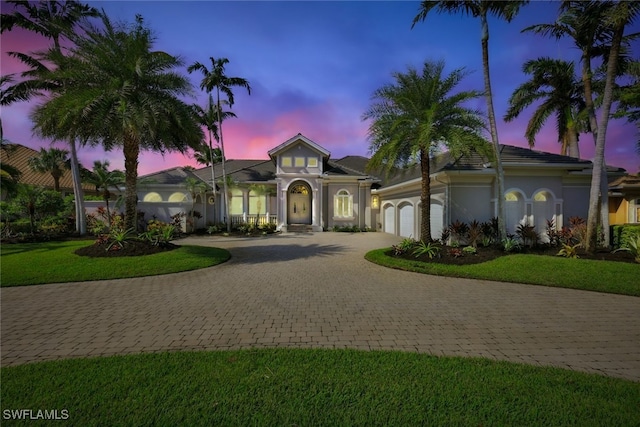 view of front of property featuring a garage and a lawn