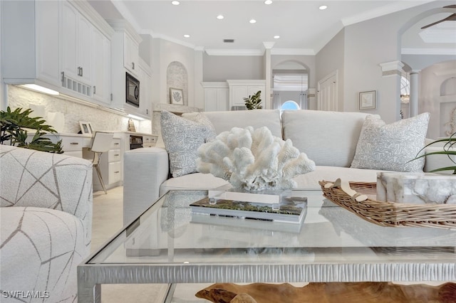 interior space with black microwave, crown molding, tasteful backsplash, and ornate columns