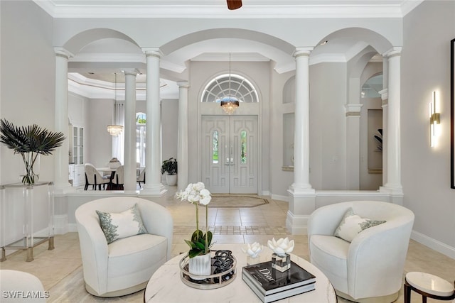 tiled entrance foyer featuring a notable chandelier and crown molding