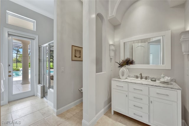 bathroom with tile patterned flooring, crown molding, and vanity