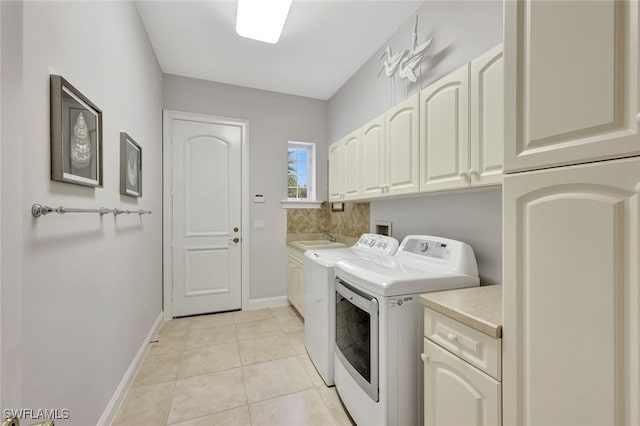 washroom featuring separate washer and dryer, cabinets, sink, and light tile patterned floors