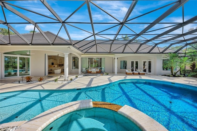 view of pool with an outdoor hangout area, an in ground hot tub, a lanai, french doors, and a patio area