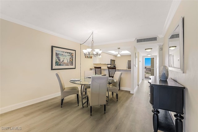 dining space featuring light wood-type flooring, a chandelier, and ornamental molding