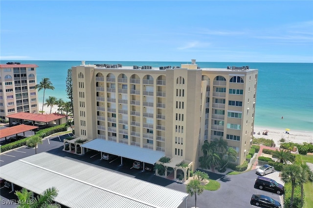 view of building exterior with a water view and a view of the beach