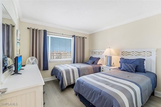 bedroom featuring ornamental molding and light hardwood / wood-style flooring