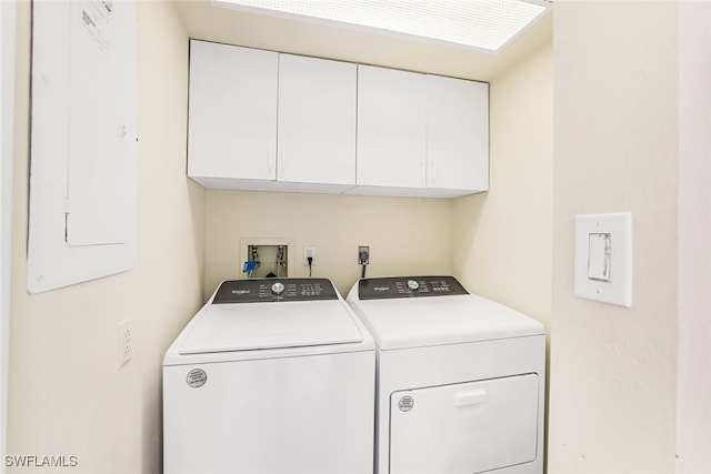 laundry room with cabinets, electric panel, and washing machine and dryer