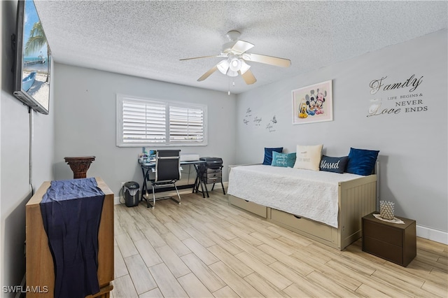 bedroom featuring light hardwood / wood-style floors, a textured ceiling, and ceiling fan