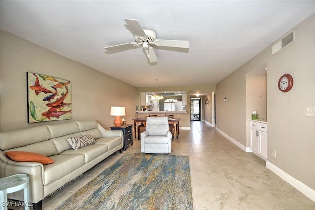 living room featuring ceiling fan with notable chandelier