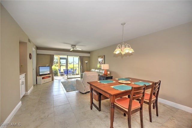 tiled dining room featuring ceiling fan with notable chandelier