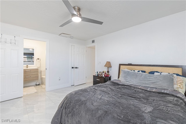 bedroom with ensuite bath, a textured ceiling, and ceiling fan