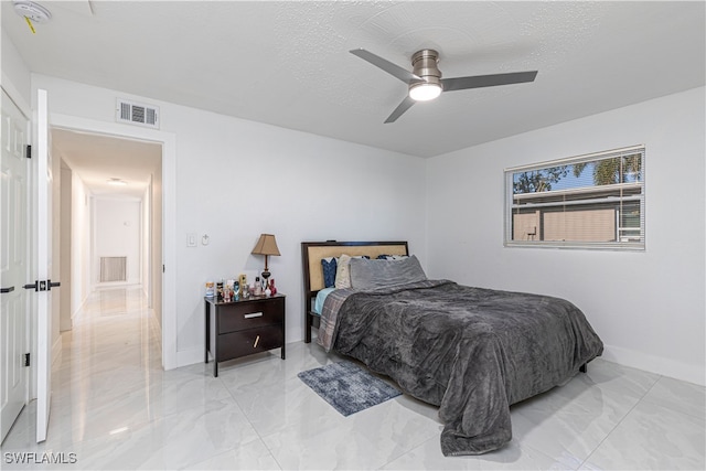 bedroom with a textured ceiling and ceiling fan