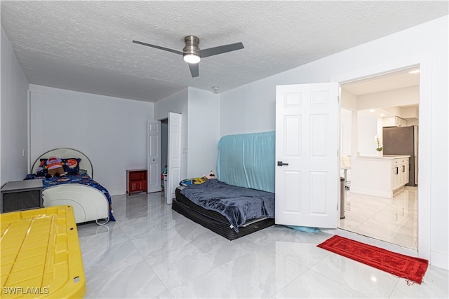 bedroom with stainless steel refrigerator, a textured ceiling, ensuite bathroom, and ceiling fan