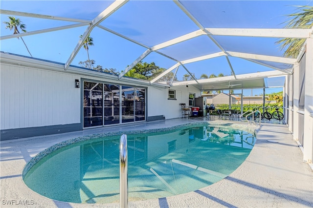 view of swimming pool with a patio area and a lanai