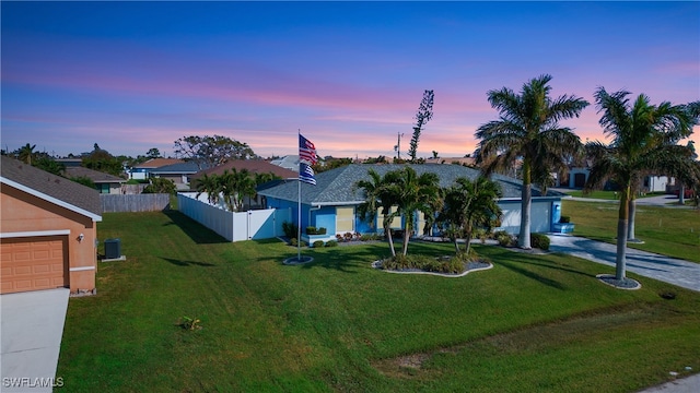 ranch-style house with a garage and a yard