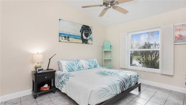 bedroom featuring ceiling fan, light tile patterned floors, and vaulted ceiling