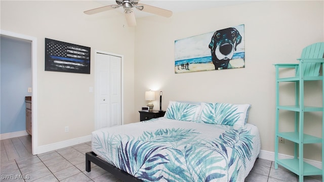 bedroom with ceiling fan, tile patterned floors, and a closet