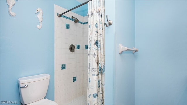 bathroom featuring toilet and curtained shower