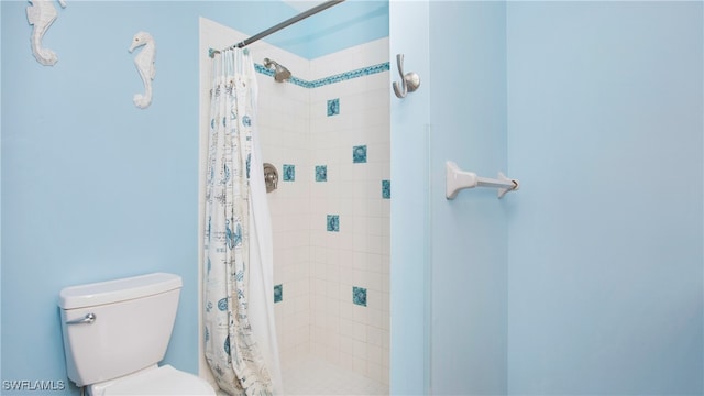 bathroom with toilet and a shower with curtain