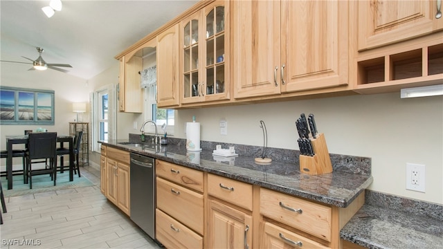 kitchen featuring dark stone counters, light brown cabinetry, ceiling fan, lofted ceiling, and dishwasher