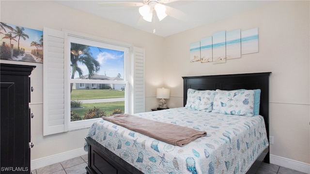 tiled bedroom with ceiling fan and multiple windows