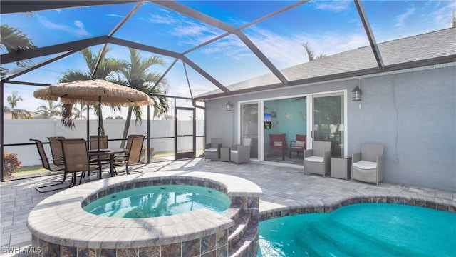 view of pool featuring glass enclosure, an in ground hot tub, and a patio area