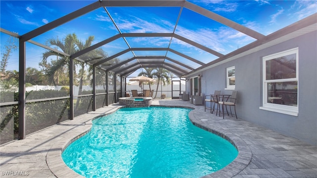 view of pool featuring glass enclosure, a patio, and an in ground hot tub