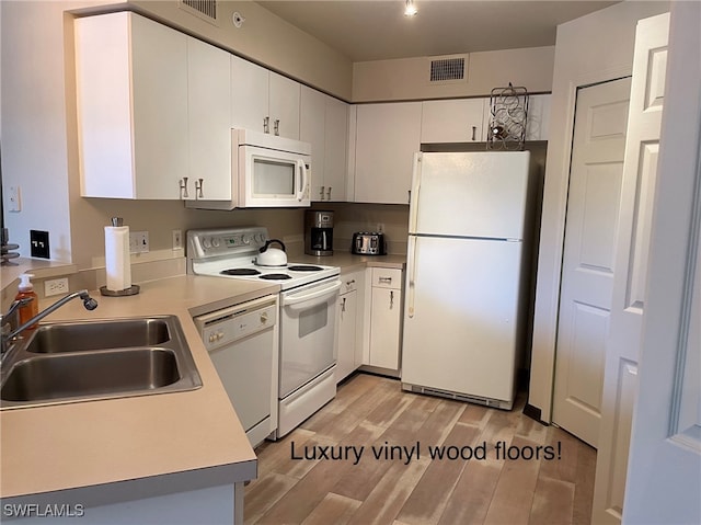 kitchen featuring light hardwood / wood-style floors, white cabinets, sink, and white appliances